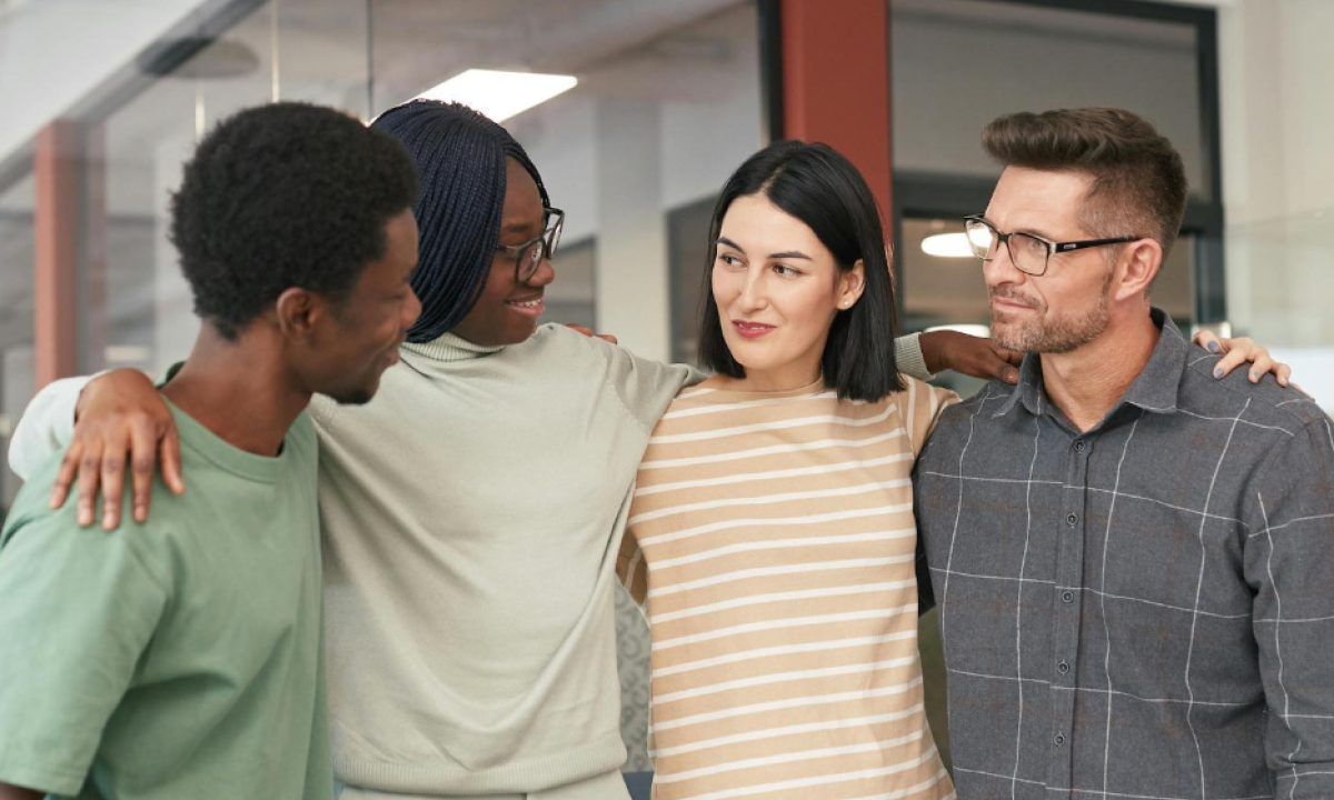 four people coming together to embrace
